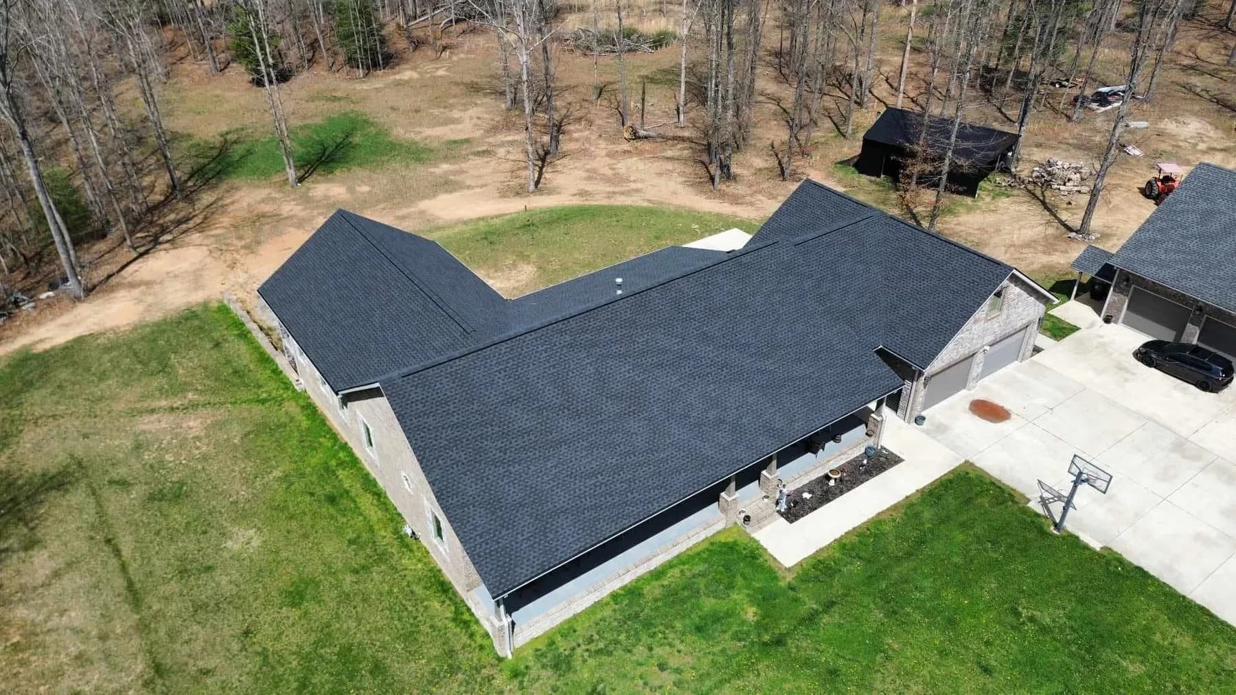 Aerial view of a black shingle roof and outdoor living area