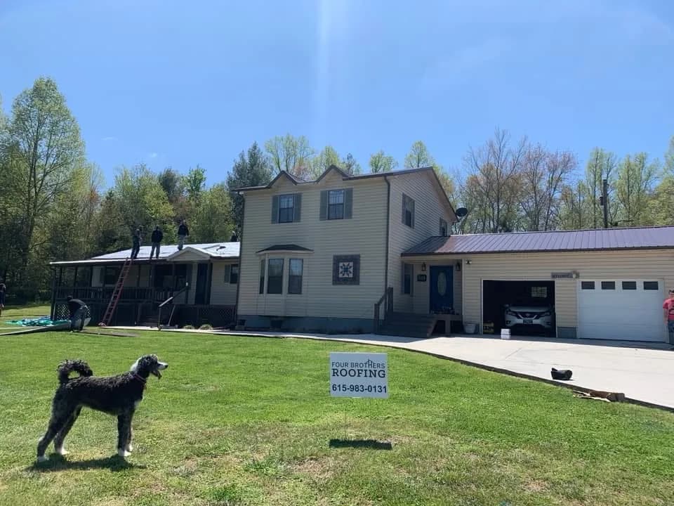 Large home and garage roofing project with yard sign