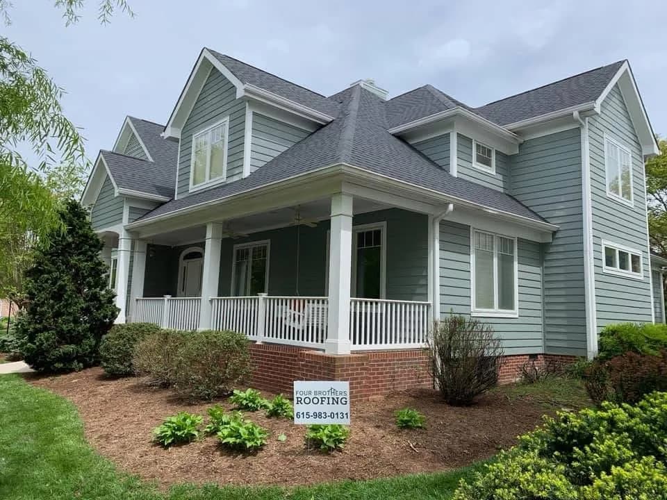 Two-story home with completed roof and Four Brothers sign