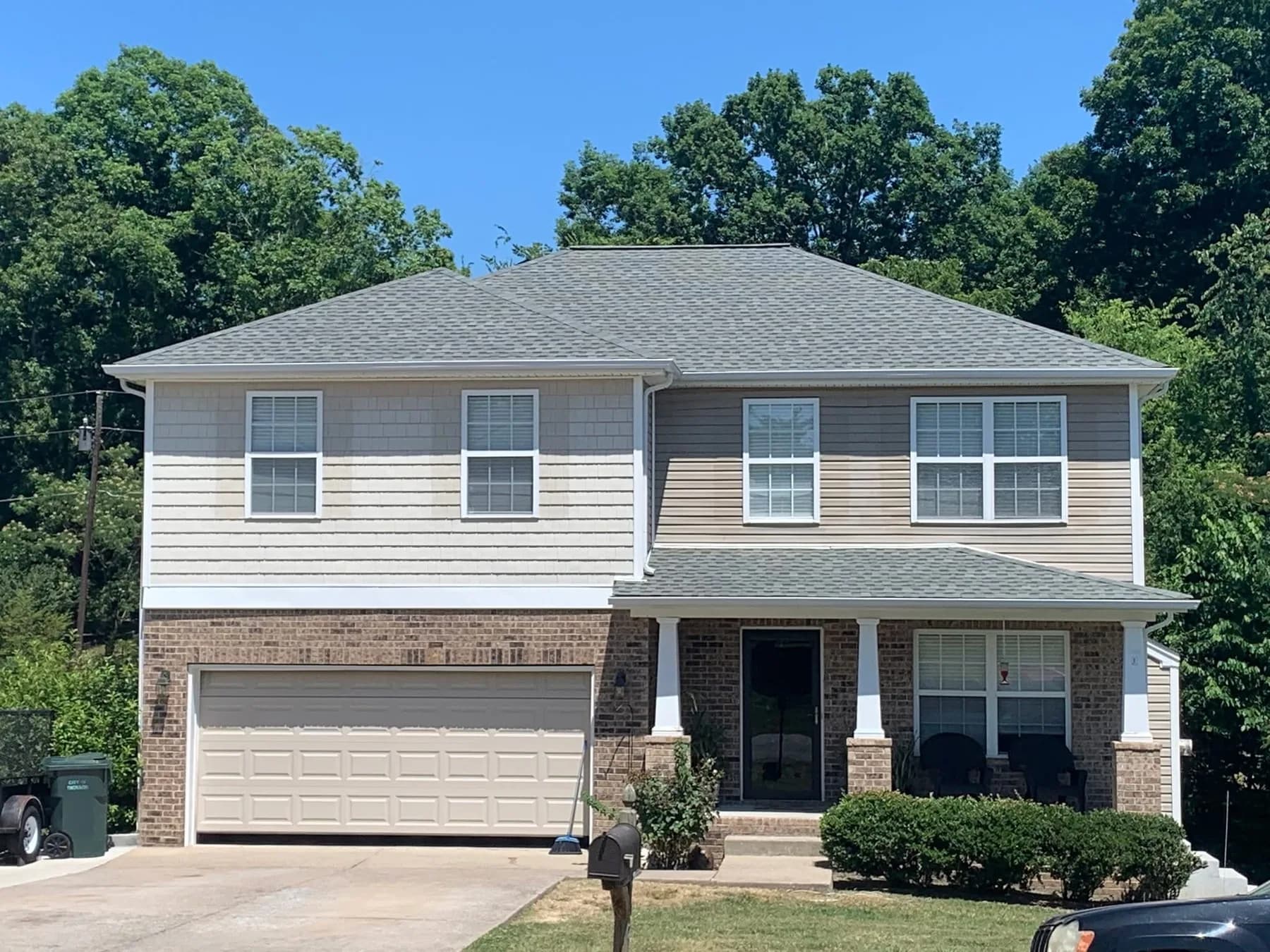 Two-story gray home with completed roof