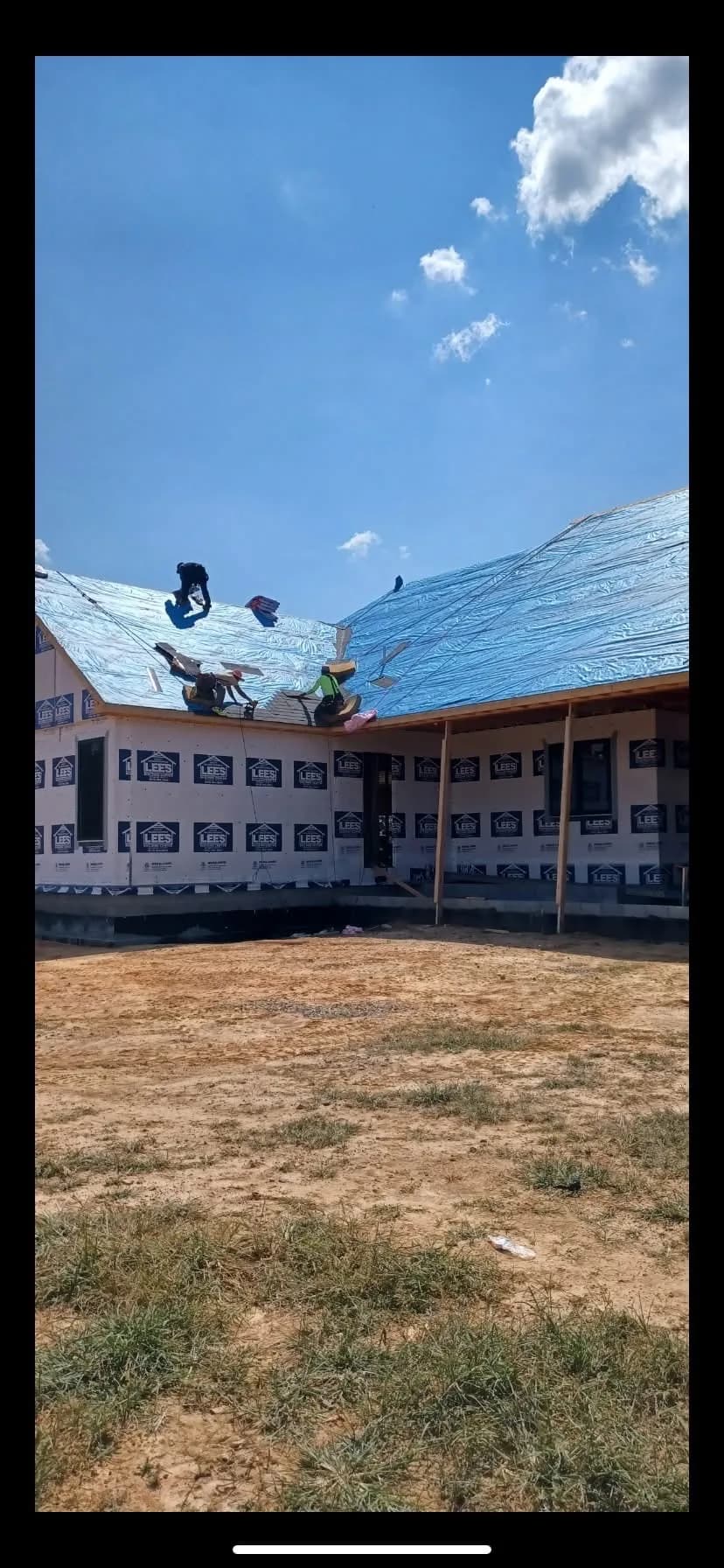 Vertical construction photo of a blue metal roof project