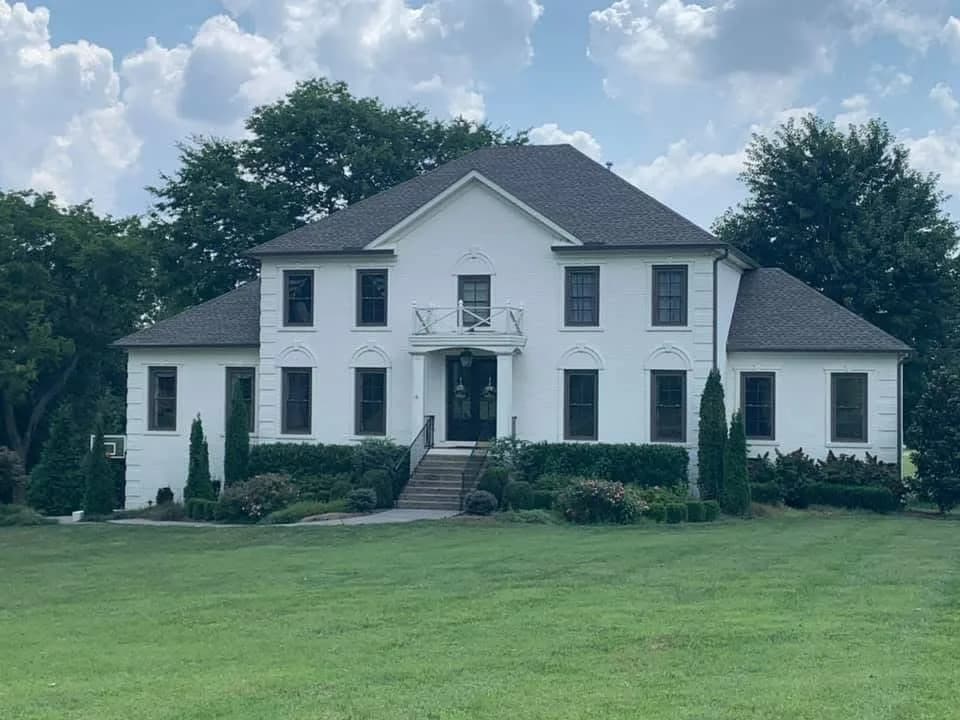 White farmhouse-style home with finished roof
